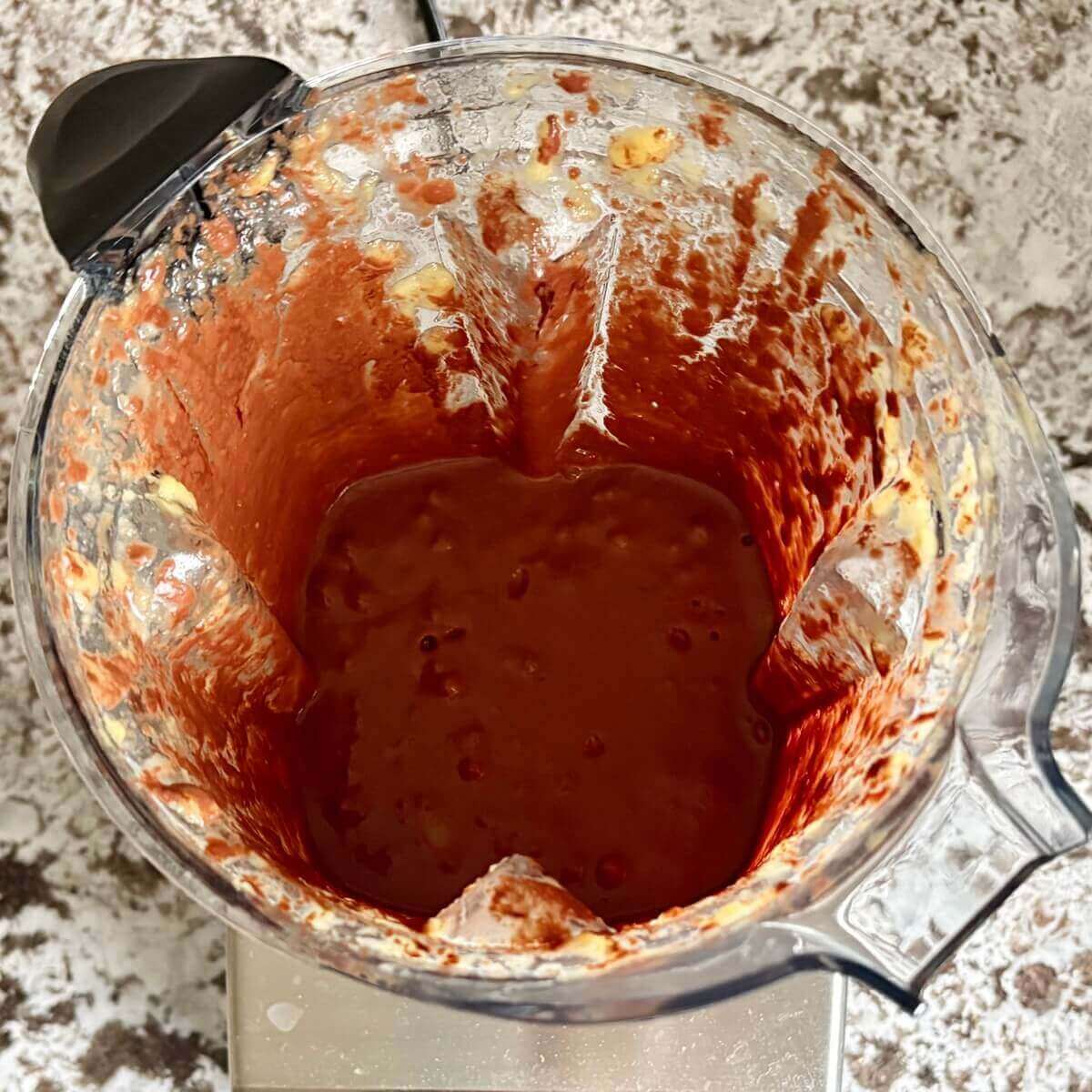 Mango, melted chocolate, and other ingredients for mousse blended in a blender.