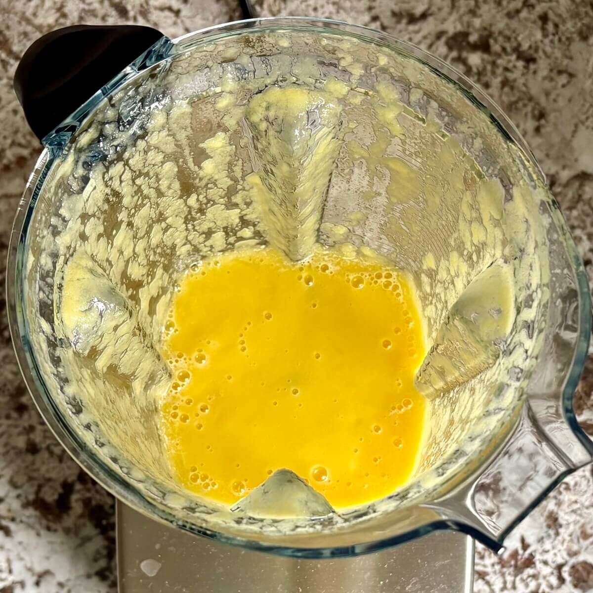 Mango and other ingredients for mousse blended in a blender.