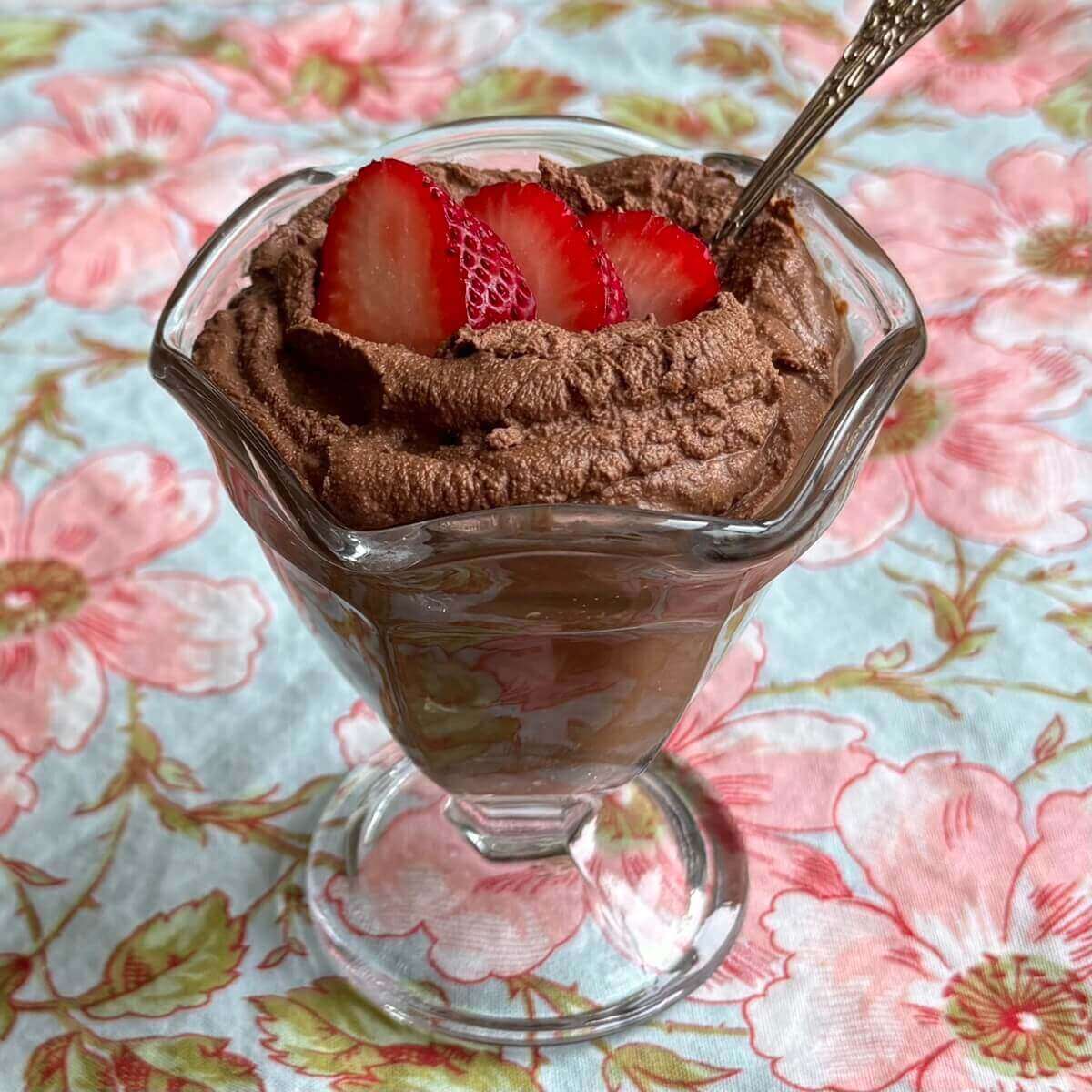 Cashew chocolate mousse topped with strawberry slices in a glass dish.