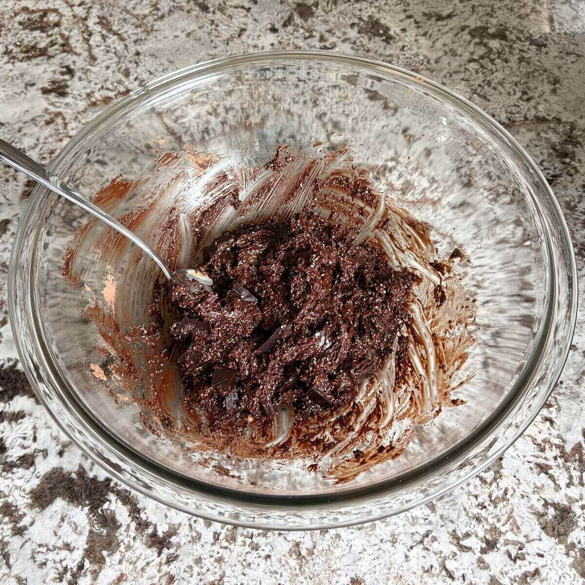 Chia cookie dough in a glass mixing bowl with a spoon.