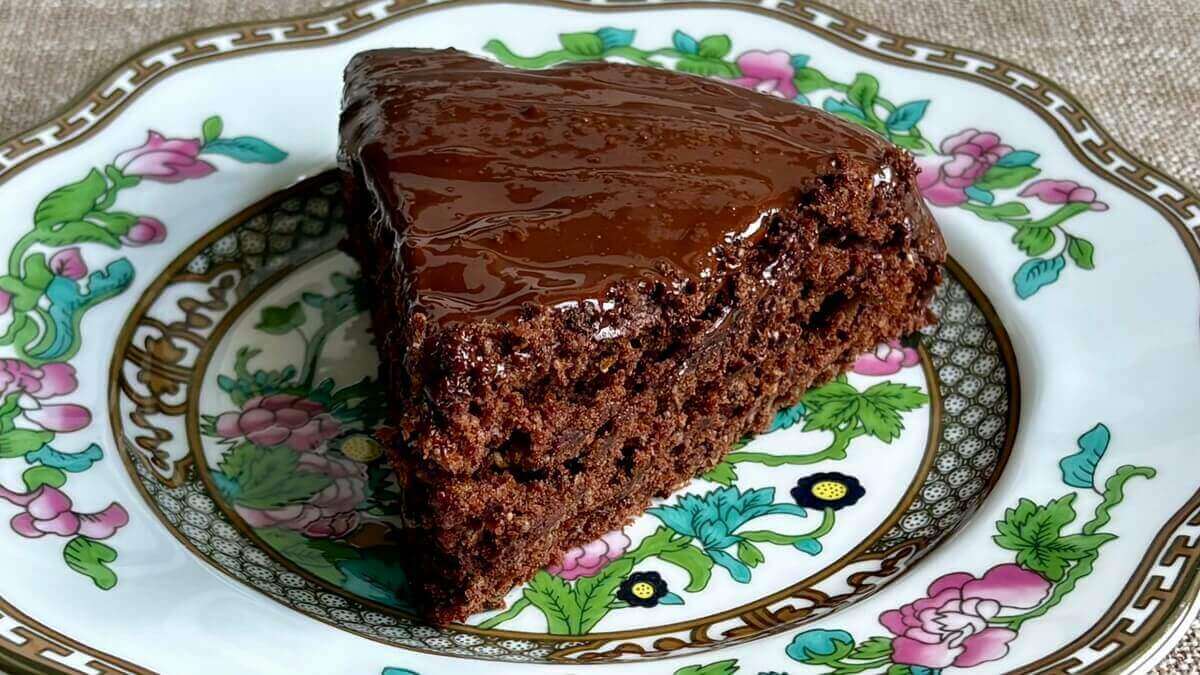 A piece of frosted chocolate chia cake on a plate.