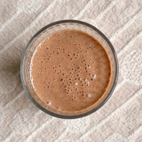 A chocolate chia smoothie on a beige placemat.