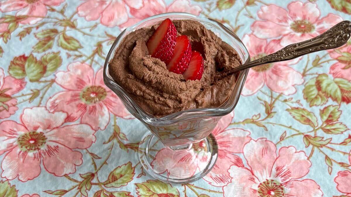 Chocolate mousse in a glass dish with an antique spoon.