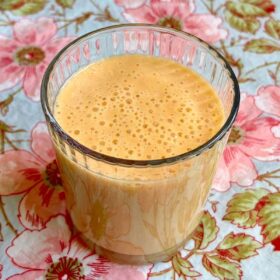 A creamy mango smoothie in a glass.