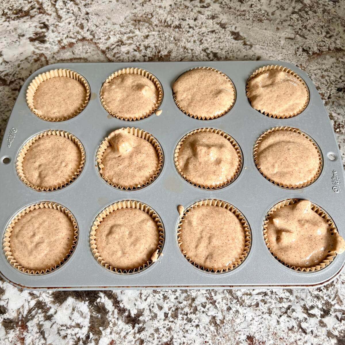Raw muffins in a baking pan.