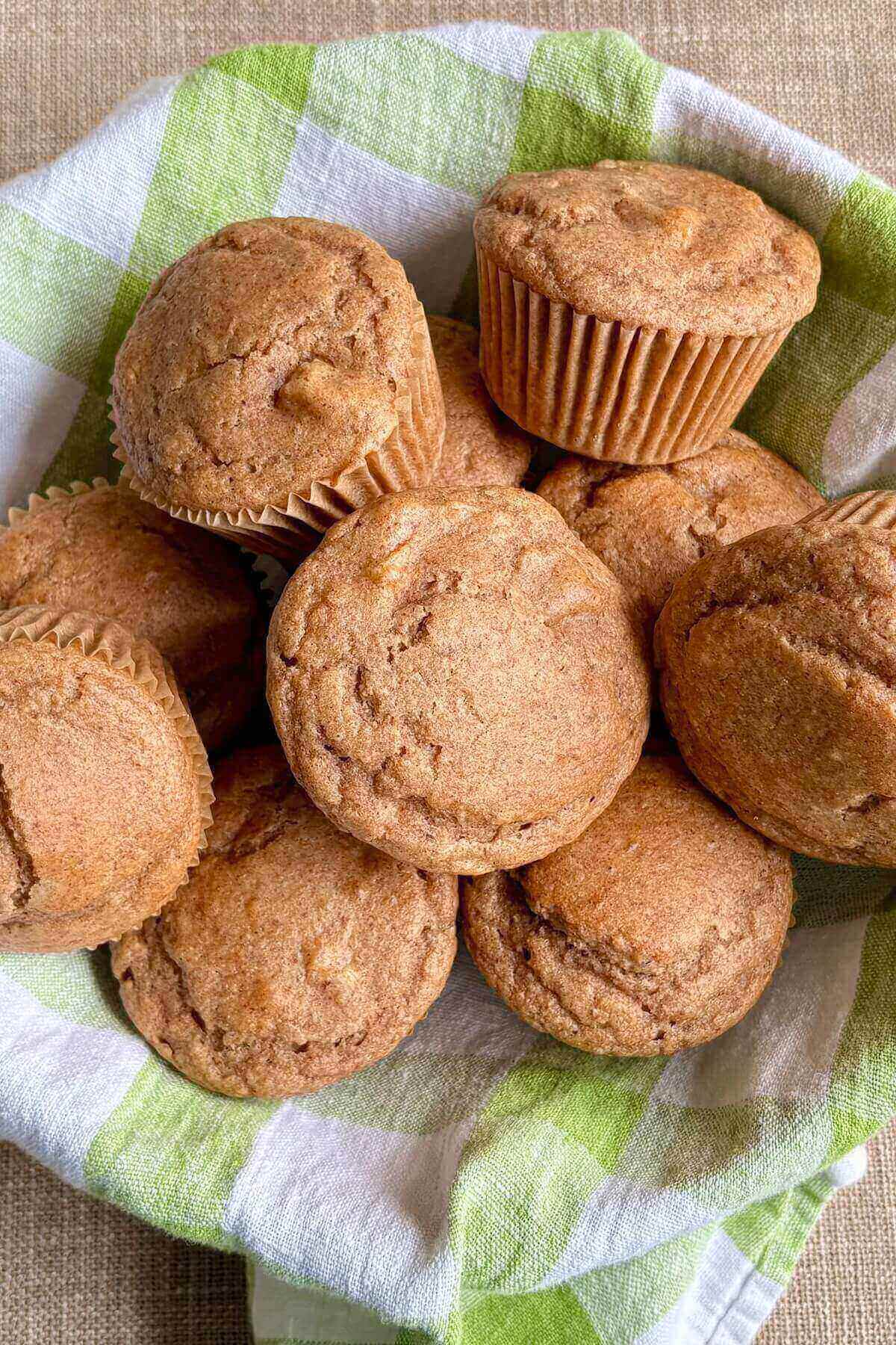 Muffins in a basket lined with a cloth.