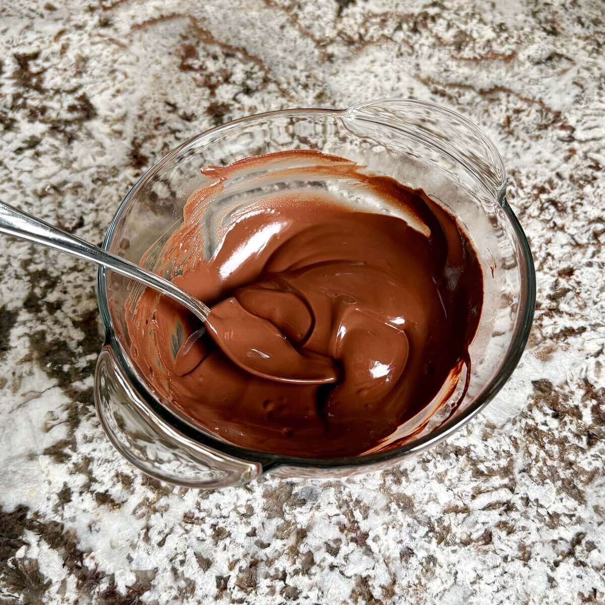 A mixture of cocoa powder and boiling water in a glass bowl.