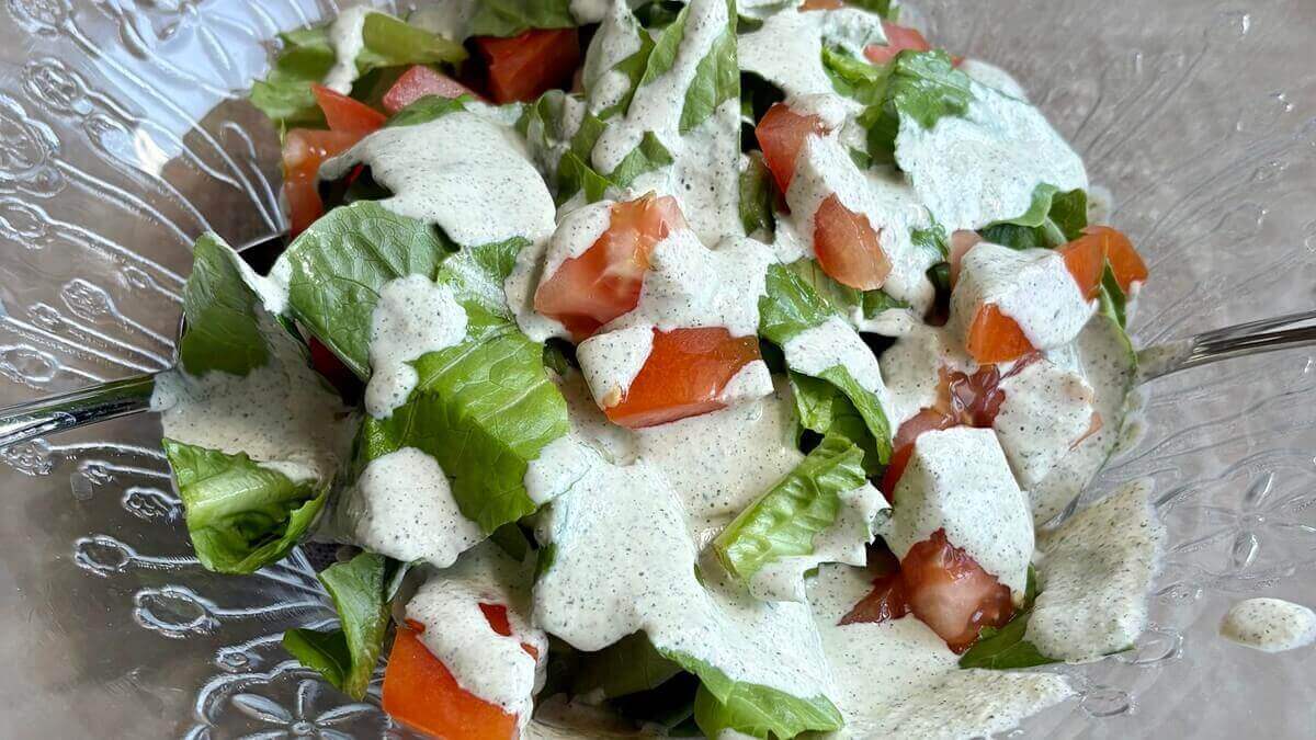 Hemp salad dressing drizzled on top of lettuce and tomatoes.