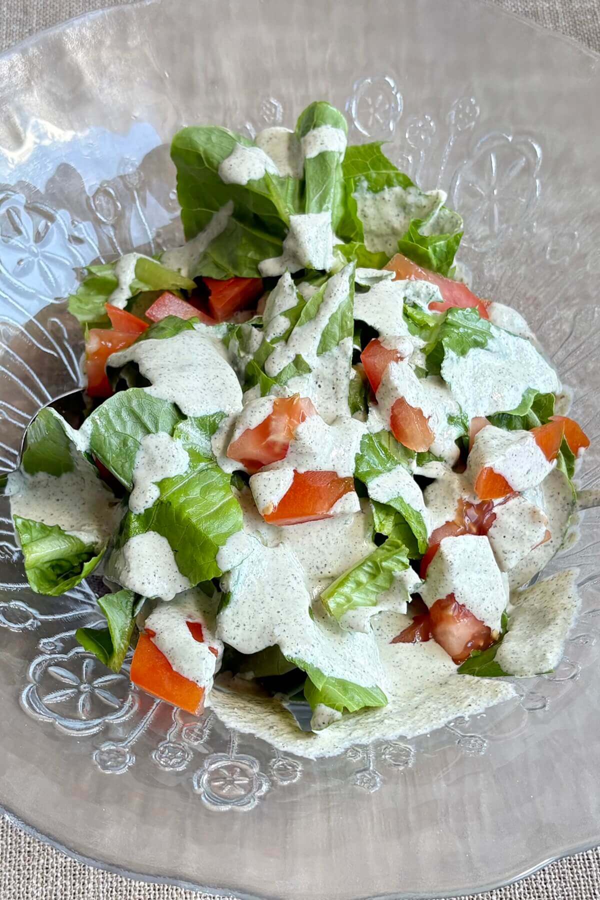 Hemp seed dressing poured on a salad in a bowl.