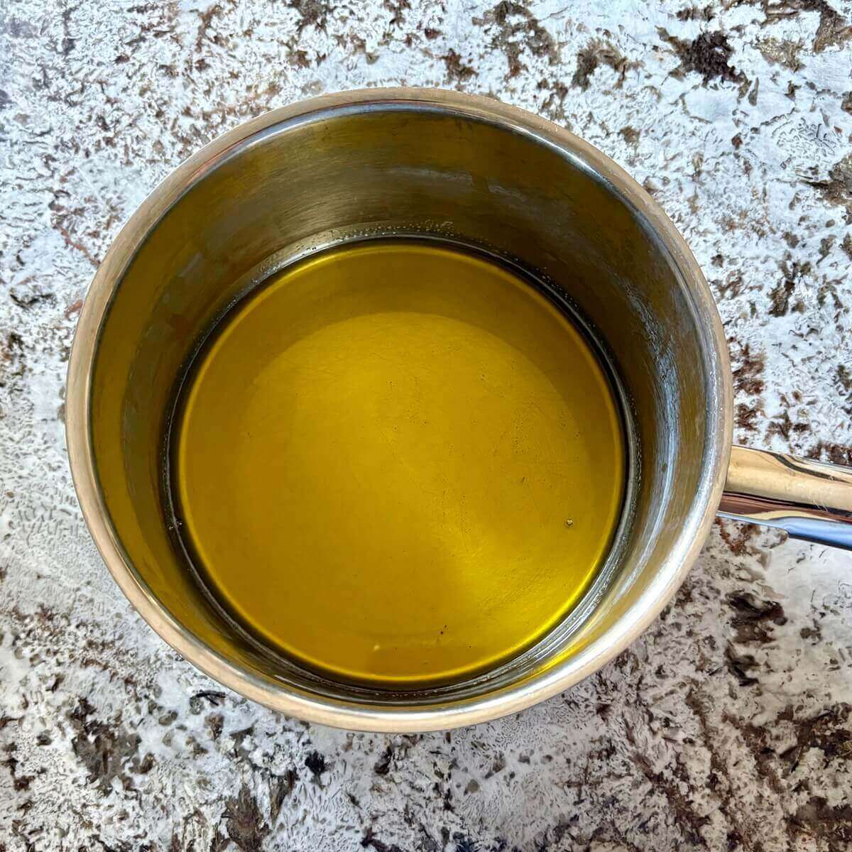 Hot melted cocoa butter in a steel pot.