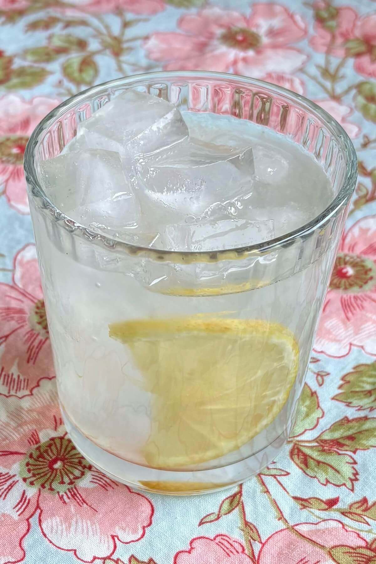 A glass of keto lemonade on a floral placemat.