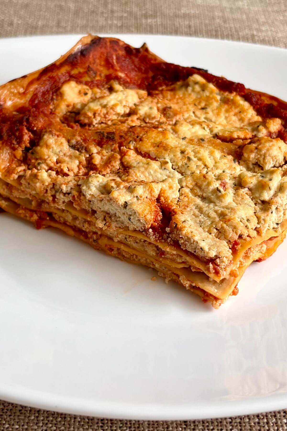 A slice of lasagna with tofu ricotta on a plate.