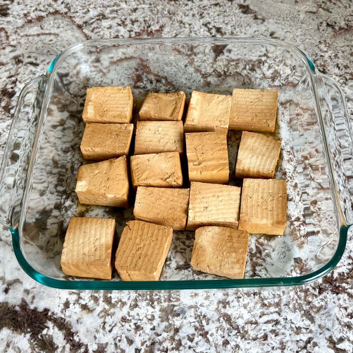 Pieces of tofu in a glass baking dish.