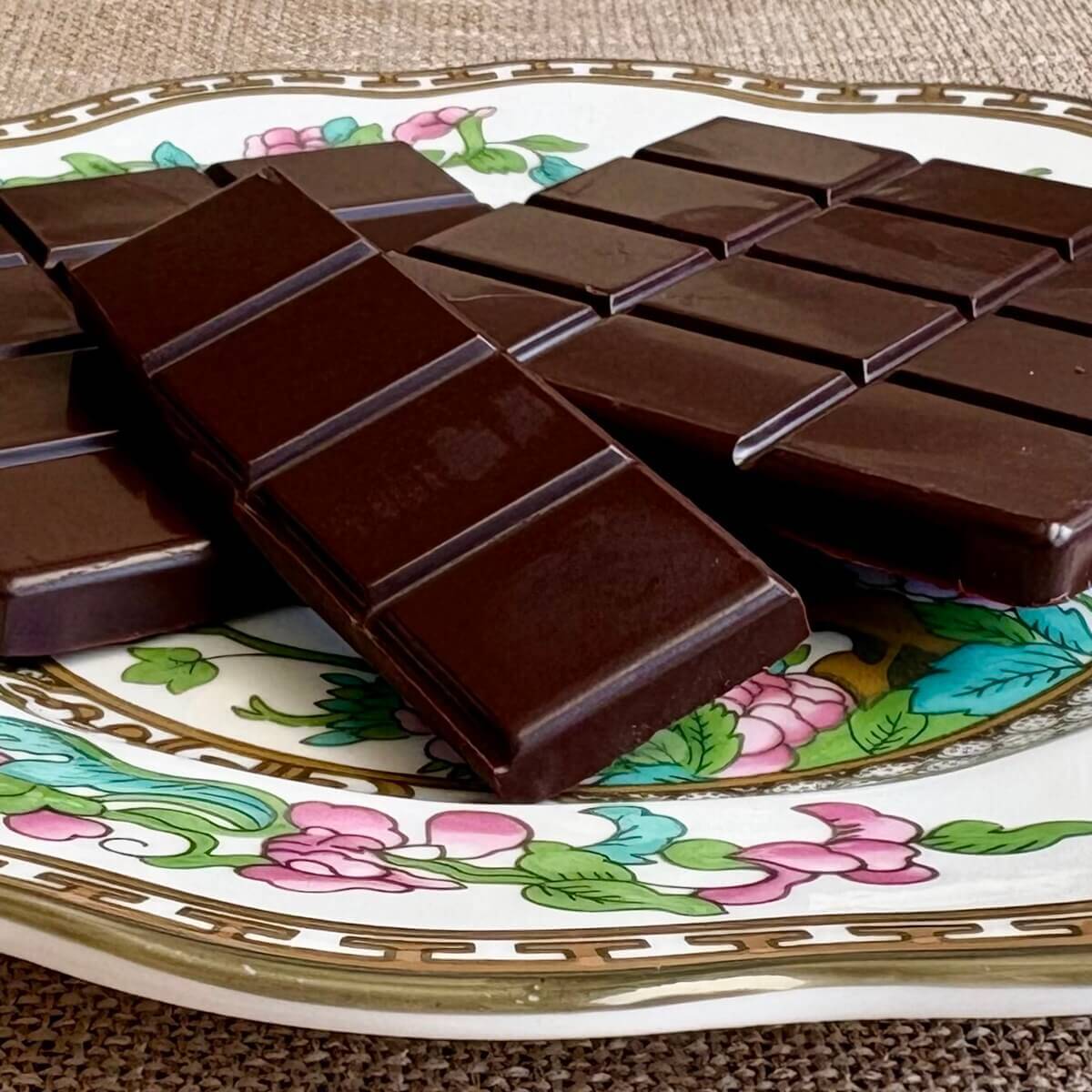 Squares of monk fruit chocolate on a vintage plate.