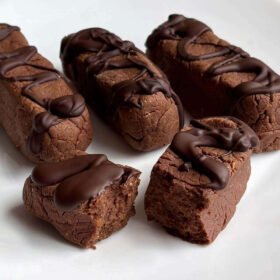 Monk fruit protein bars drizzled with dark chocolate on a plate.