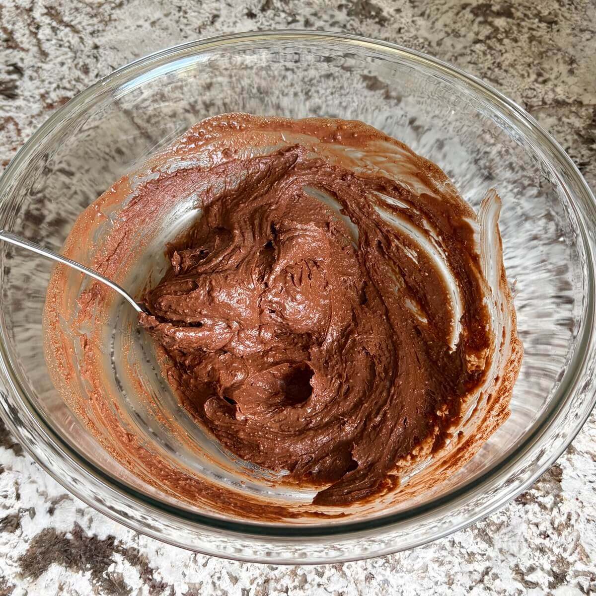 A brown thick mixture in a glass mixing bowl.