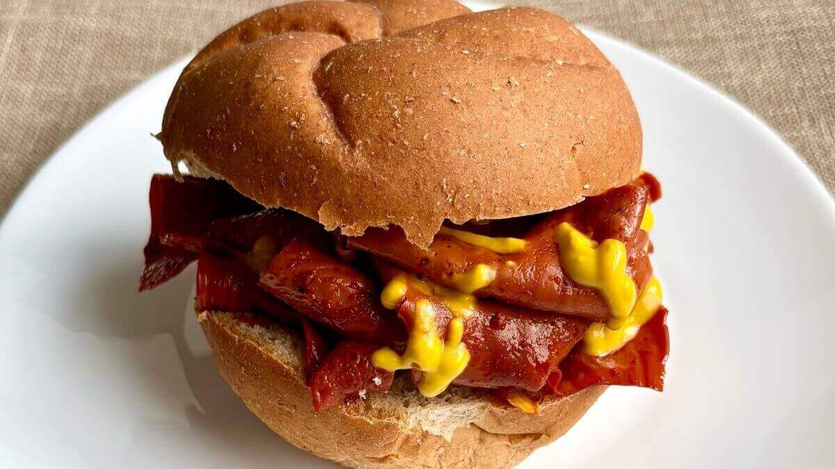 A plant-based roast beef sandwich on a plate.