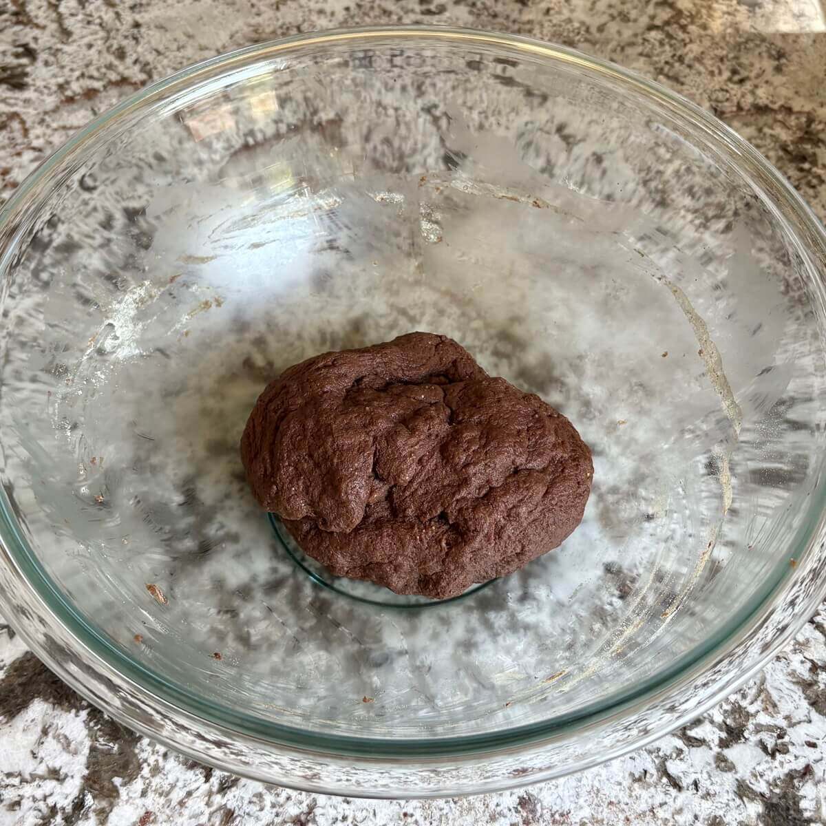 Chocolate seitan dough in a glass bowl.