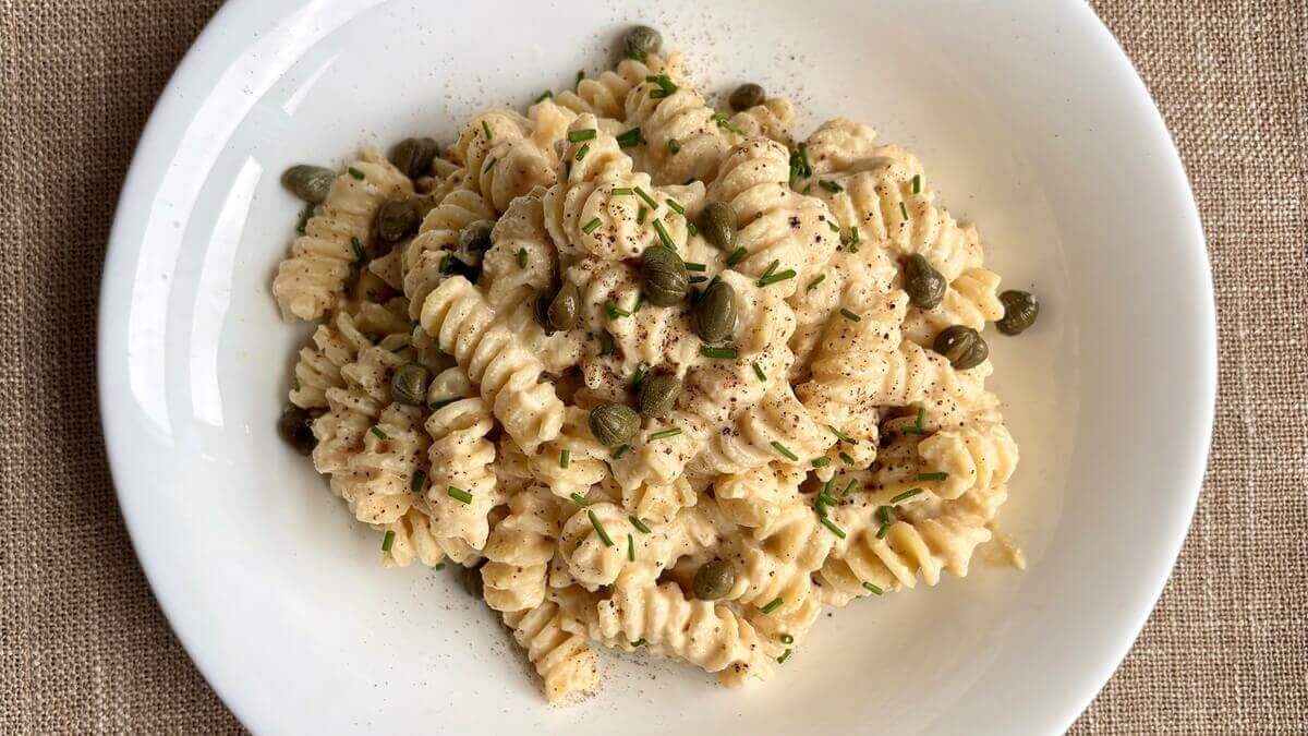 Pasta in a creamy tempeh sauce in a white bowl.