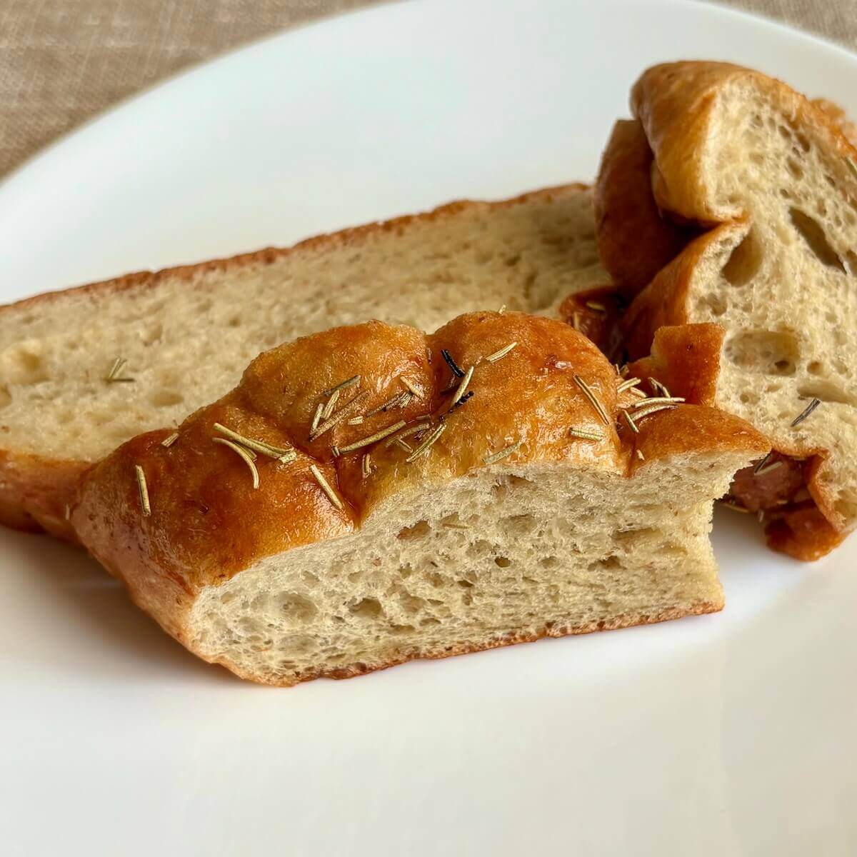 Slices of seitan bread on a white plate.