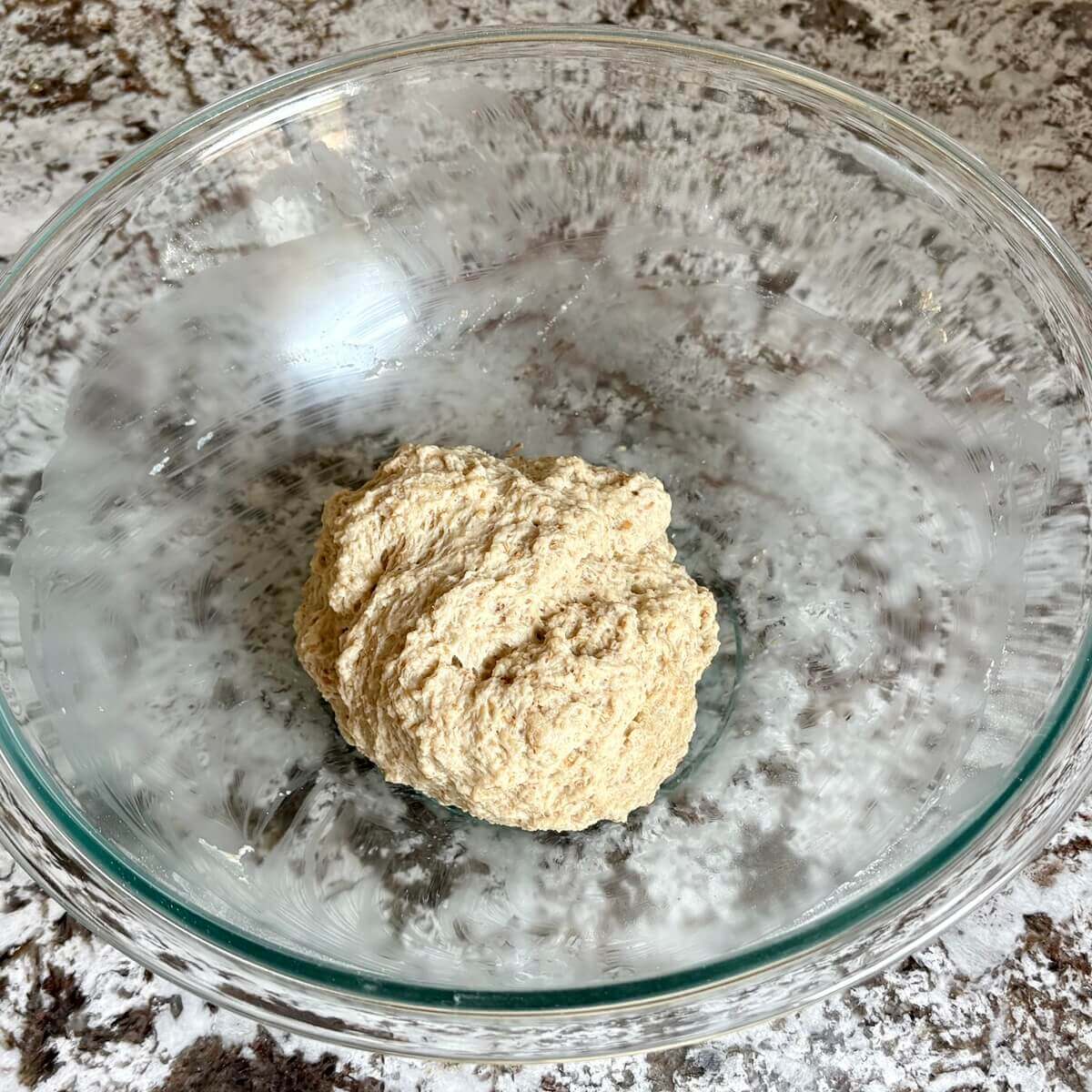 Seitan dough for bread in a glass mixing bowl.
