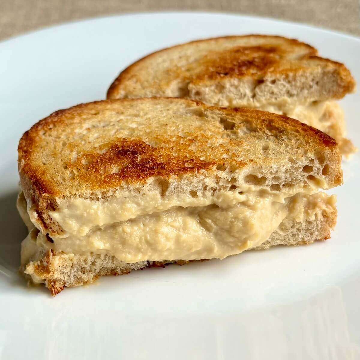 A sandwich oozing with tempeh cheese.