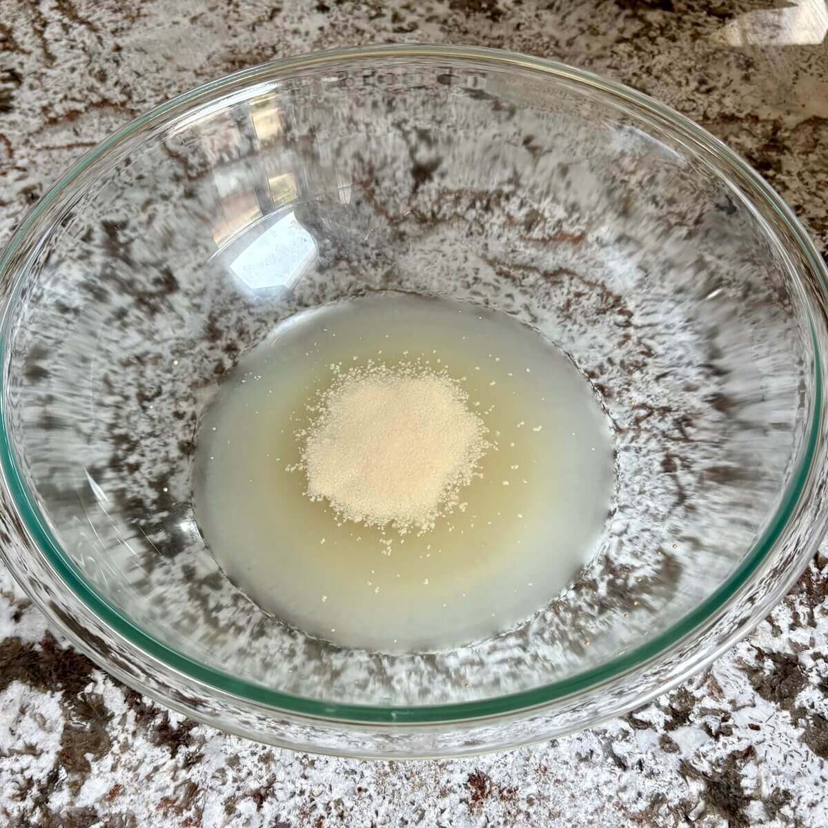 Yeast blooming in a glass mixing bowl.