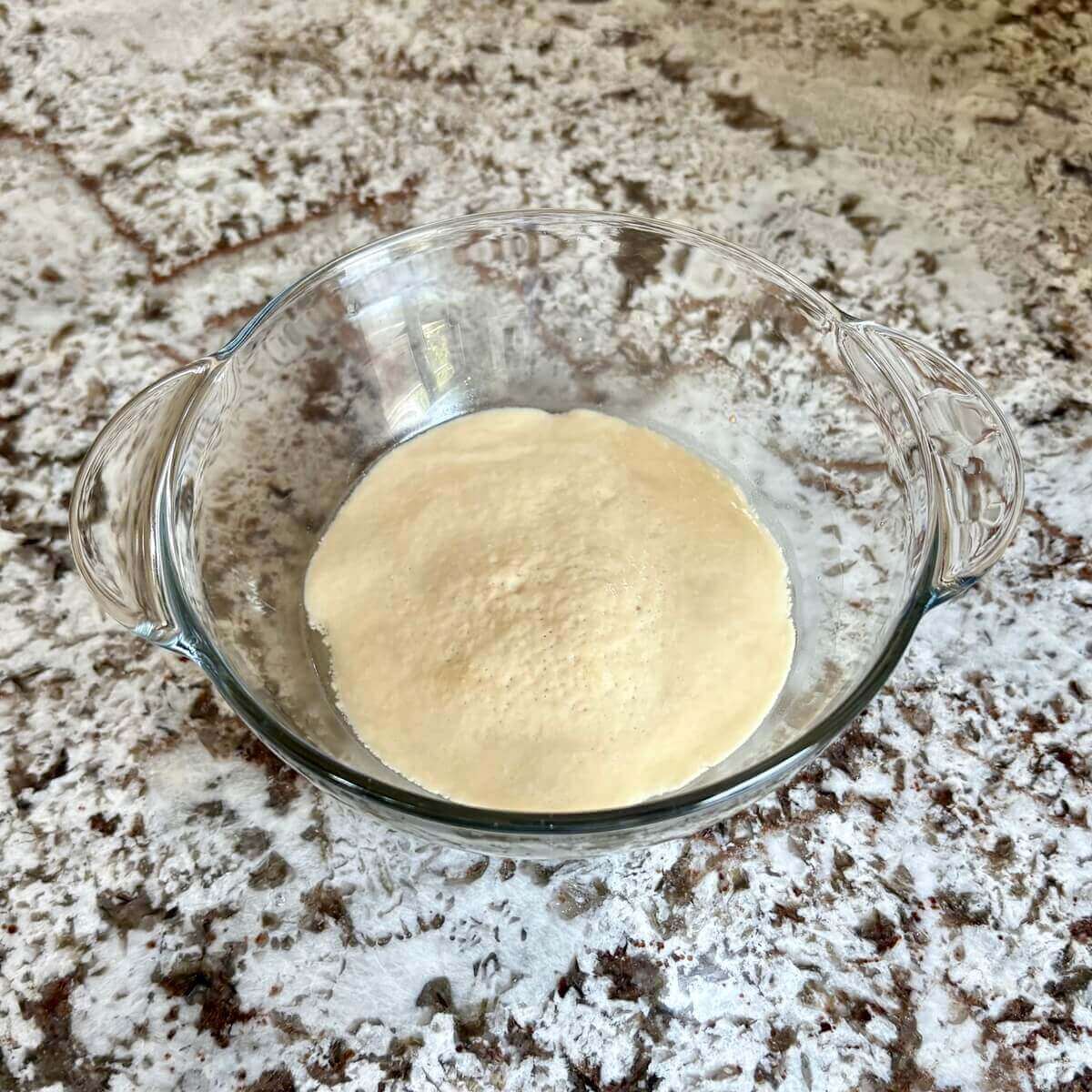 Yeast proofing in a glass bowl.
