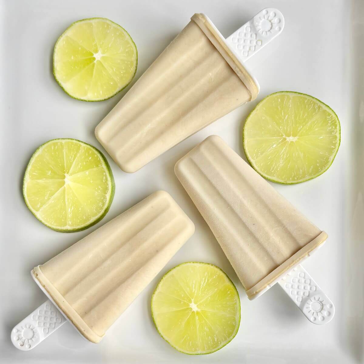 Three cashew lime popsicles on a plate.