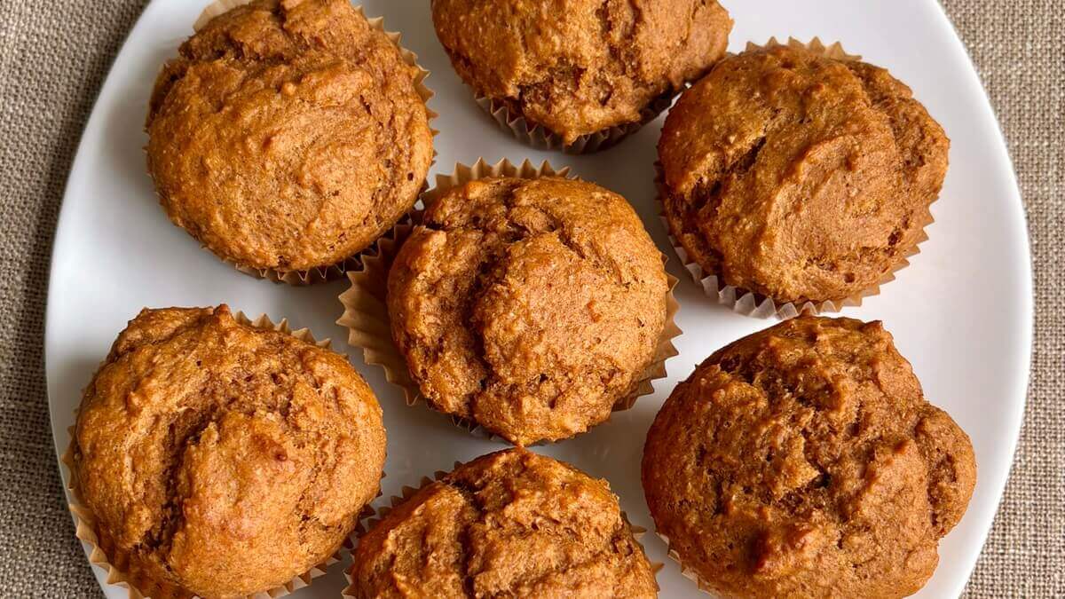Almond butter pumpkin muffins on a white plate.