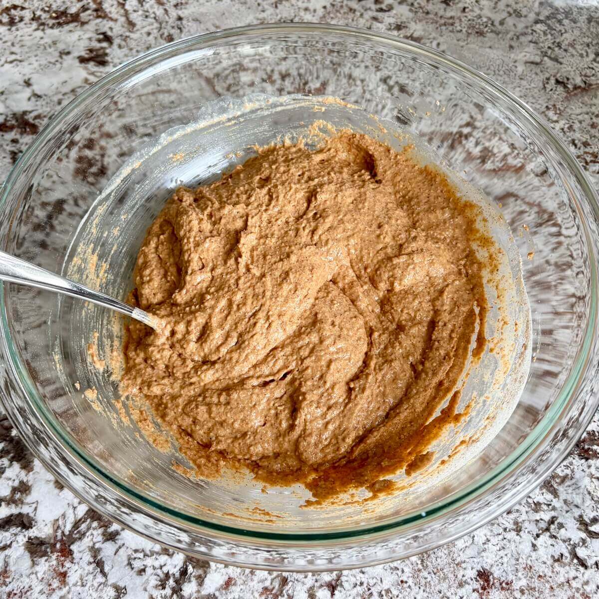 Pumpkin muffin batter in a glass bowl.