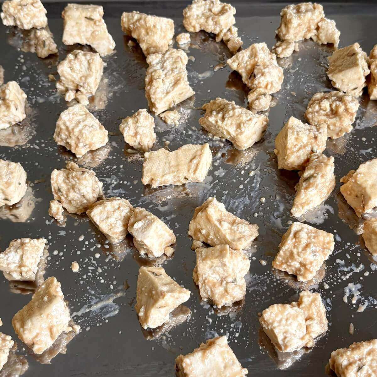 Pieces of tofu on a sheet pan.