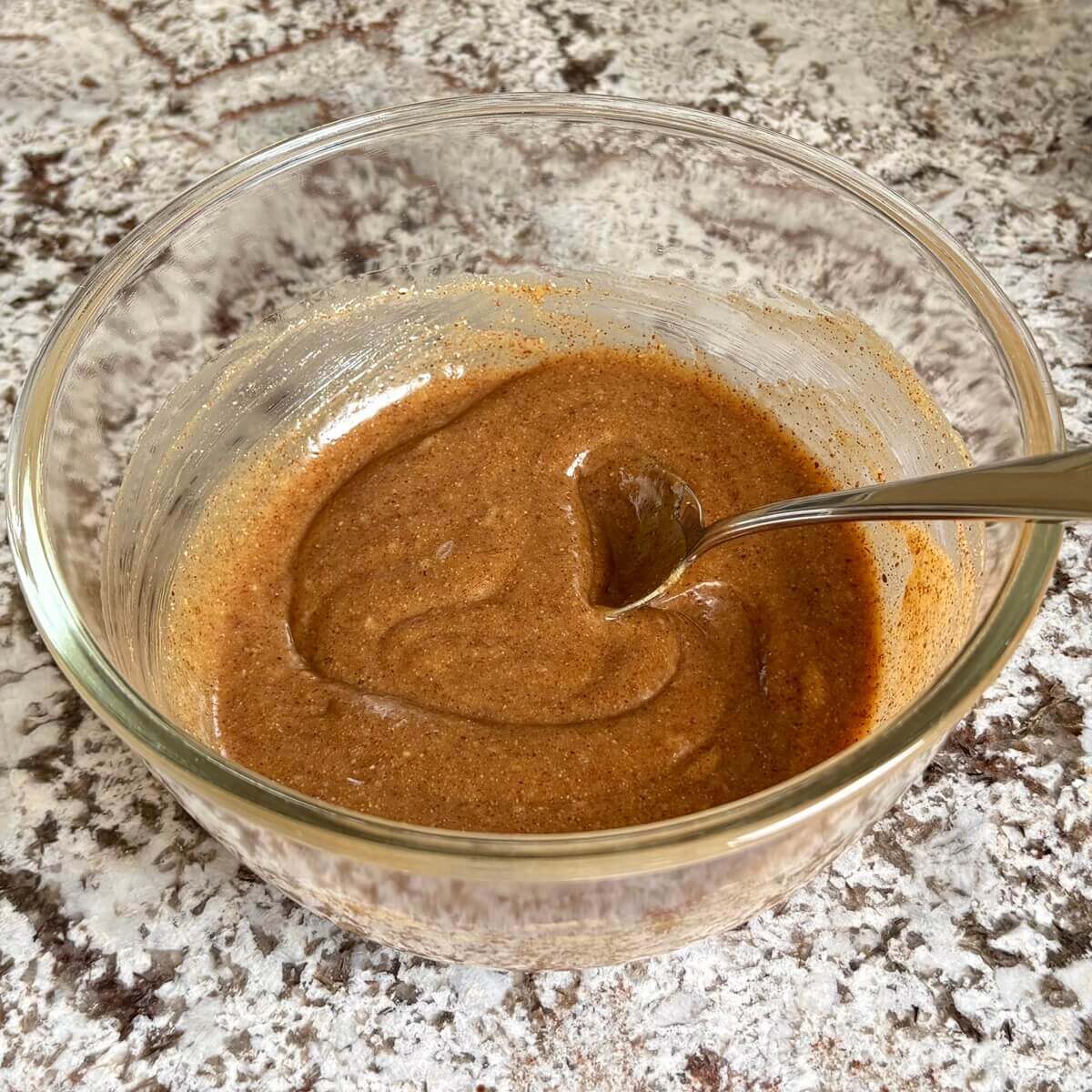 Vegan salted caramel sauce being stirred in a mixing bowl.