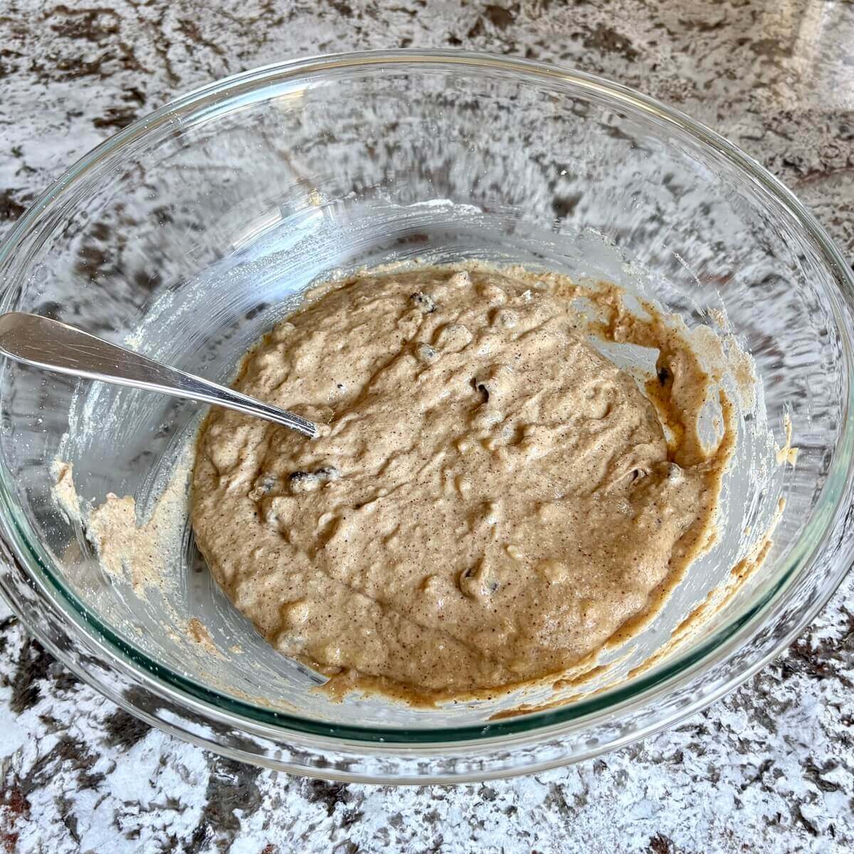 Banana bread batter in a glass mixing bowl.